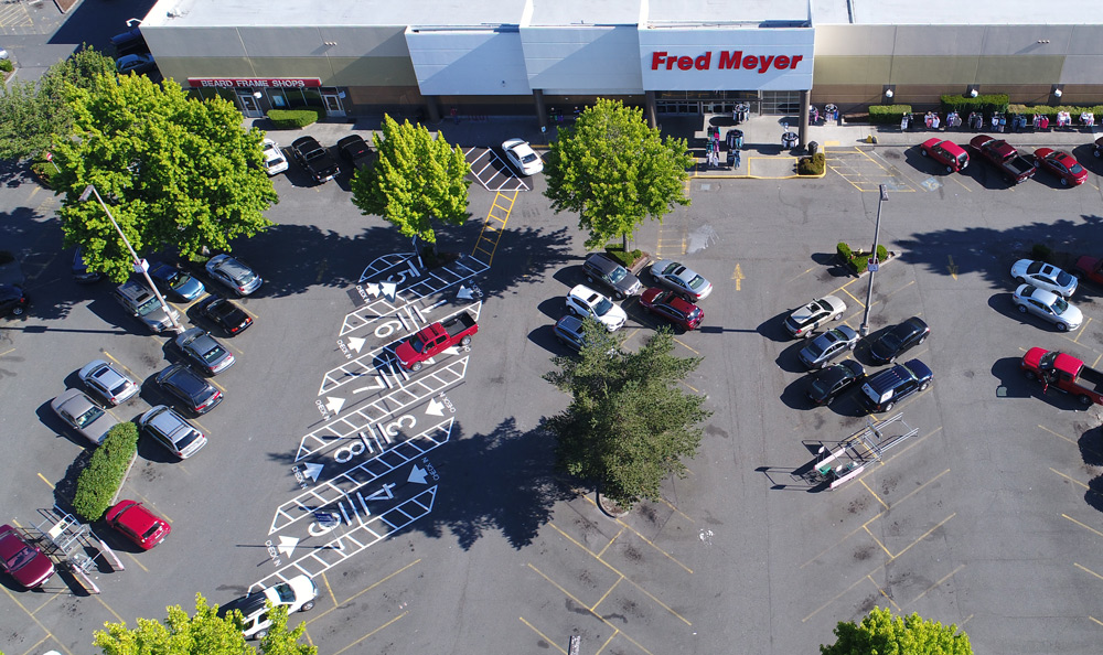 Parking lot before Eagle Asphalt Sealcoating, showing oil stains, faded asphalt and degradation